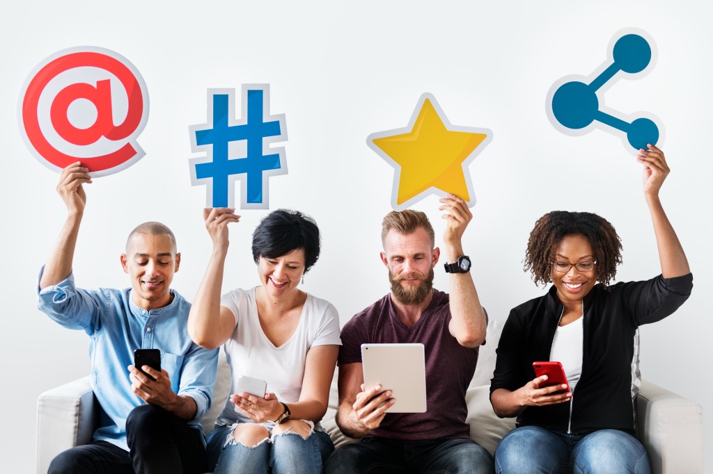 People Holding Social Media Engagement Icons